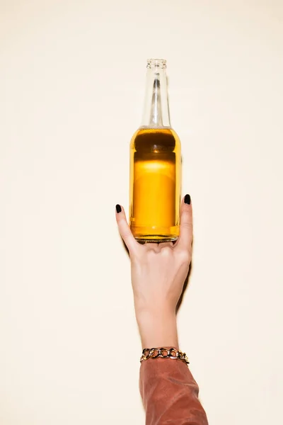 Cropped view of woman showing rock sign while holding bottle with beer on white — Stock Photo