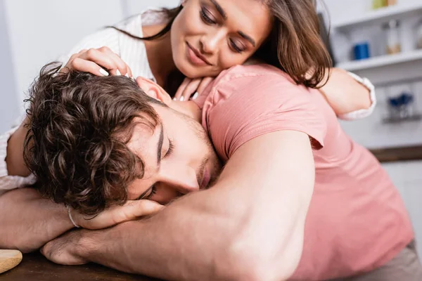 Mujer joven tocando novio con los ojos cerrados en la cocina - foto de stock