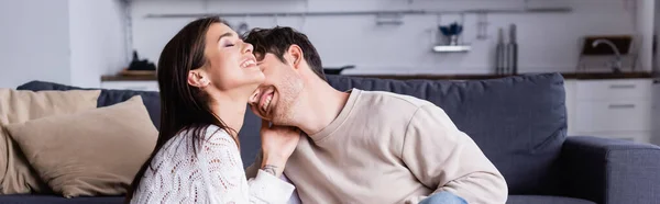 Cheerful brunette woman touching boyfriend at home, banner — Stock Photo