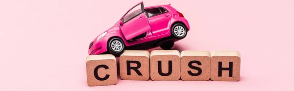 Іграшковий автомобіль і слово розчавити на кубиках на рожевому фоні, банер — стокове фото