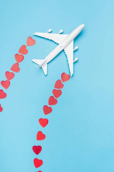 Top view of plane model and red hearts on blue background — Stock Photo