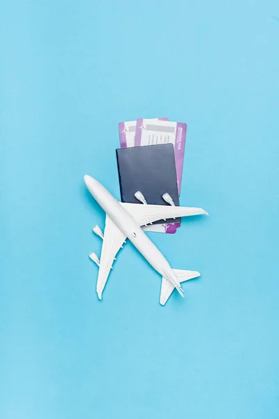 Draufsicht auf weißes Flugzeugmodell und Tickets auf blauem Hintergrund — Stockfoto