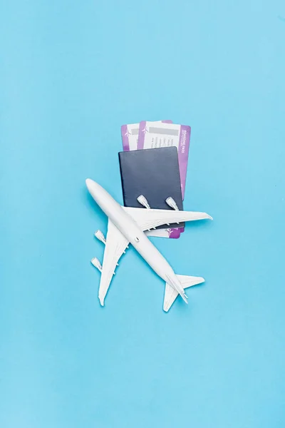 Top view of white plane model and tickets on blue background — Stock Photo