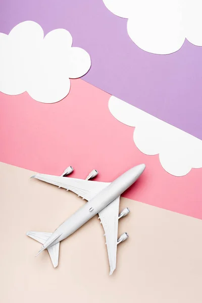 Vista superior del modelo plano blanco sobre fondo colorido con nubes — Stock Photo