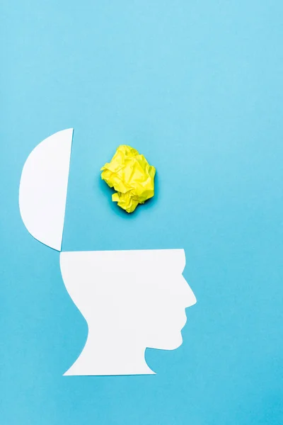 Draufsicht auf Papier menschlicher Kopf und zerknülltes Papier auf blauem Hintergrund — Stockfoto
