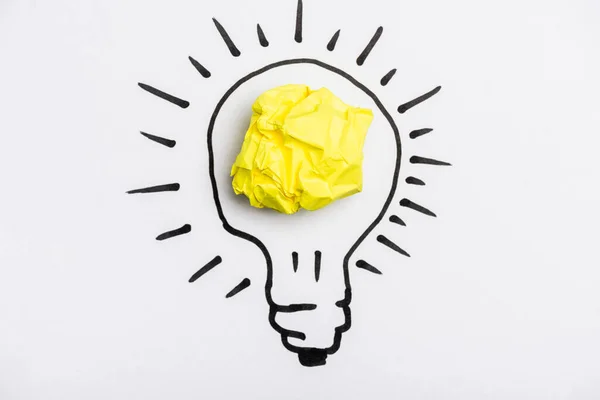 Top view of light bulb with crumpled paper on white background — Stock Photo