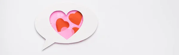 Vista superior de la burbuja del discurso con los corazones en el fondo blanco, bandera - foto de stock