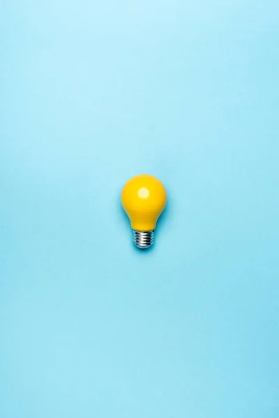 Top view yellow light bulb on blue background — Stock Photo