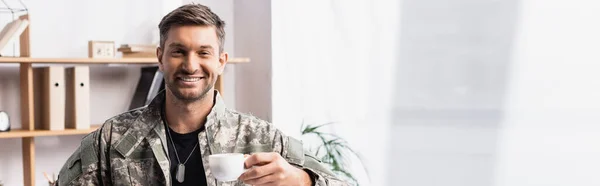 Homem militar alegre em uniforme segurando xícara de café, banner — Fotografia de Stock