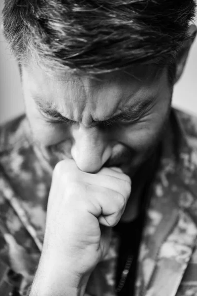 Soldado en uniforme militar llorando con los ojos cerrados, monocromo - foto de stock