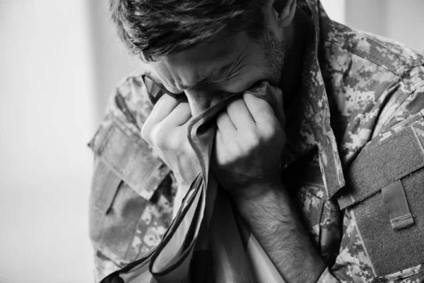 Military man in uniform crying while holding american flag, monochrome — Stock Photo