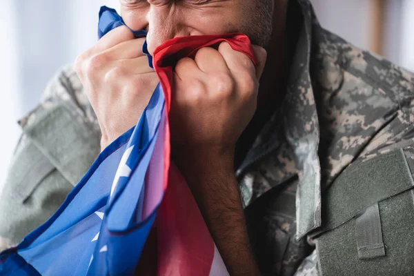 Vista ritagliata dell'uomo militare in uniforme che piange mentre tiene la bandiera dell'America — Foto stock