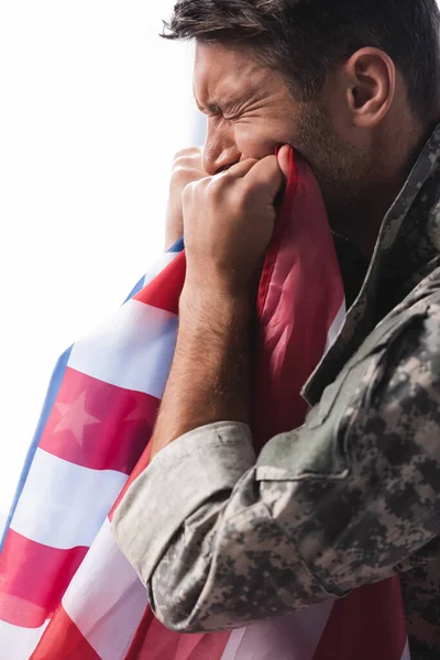 Side view of military man in uniform crying while holding flag of america — Stock Photo