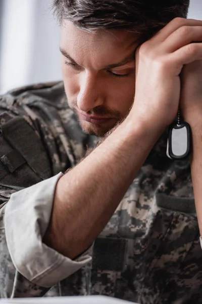 Triste soldado en uniforme de camuflaje con etiqueta militar - foto de stock