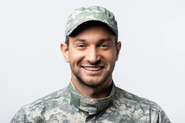 Feliz militar en uniforme y gorra sonriente aislado en blanco - foto de stock
