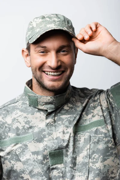 Hombre militar feliz en uniforme tapa de fijación aislado en blanco - foto de stock