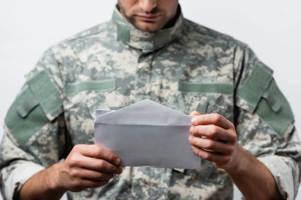 Enveloppe dans les mains de l'homme militaire patriotique en uniforme sur fond flou isolé sur blanc — Photo de stock