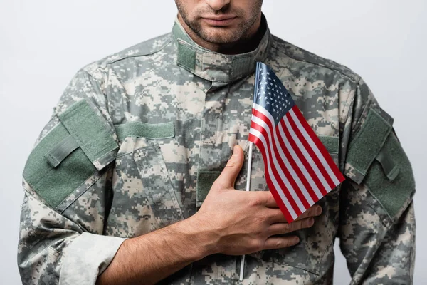 Vista cortada do homem militar patriótico em uniforme segurando bandeira americana isolada no branco — Fotografia de Stock
