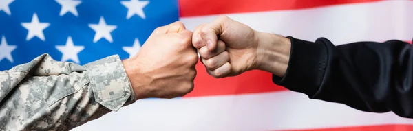 Abgeschnittene Ansicht von Soldat, der mit Zivilmann nahe der amerikanischen Flagge auf verschwommenem Hintergrund zusammenstößt, Banner — Stockfoto