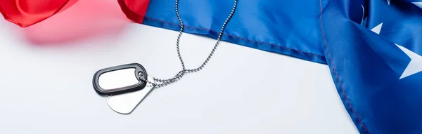 Blank metallic badge on chain near american flag on white, banner — Stock Photo