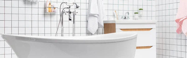 Baignoire blanche dans la salle de bain moderne avec serviettes et articles de toilette, bannière — Photo de stock