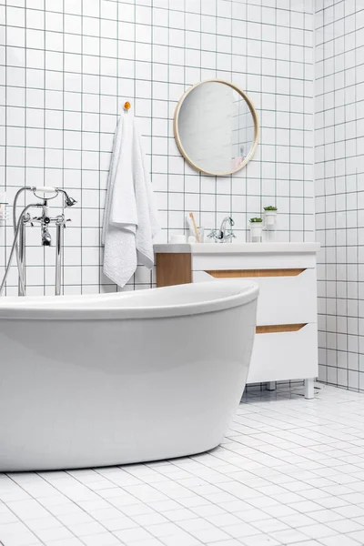 Нижняя часть современной белой ванной комнаты с полотенцем и растениями — стоковое фото