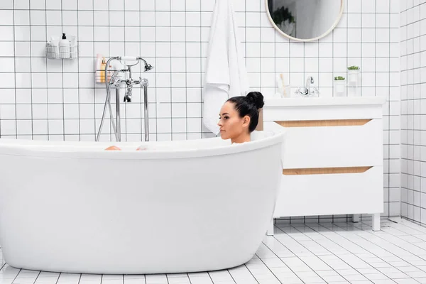 Брюнетка принимает ванну в современной ванной — стоковое фото