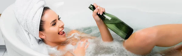 Fröhliche Frau badet mit Flasche Champagner zu Hause, Banner — Stockfoto