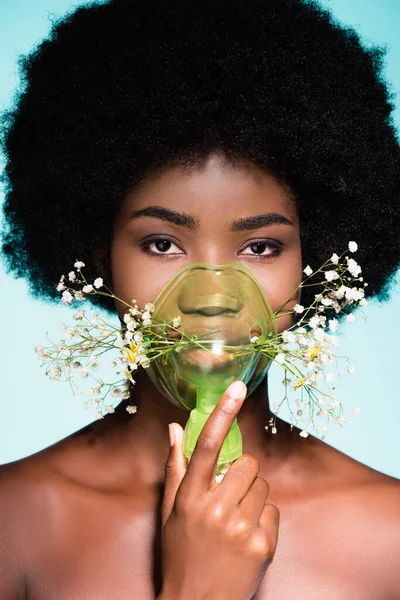 Jovem afro-americana com flores em inalador isolado em fundo azul — Fotografia de Stock