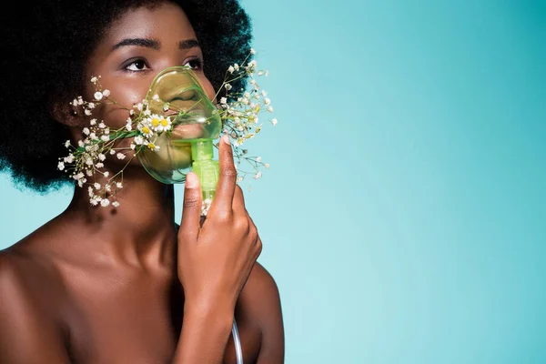 Afro-américaine jeune femme avec des fleurs dans inhalateur isolé sur fond bleu — Photo de stock