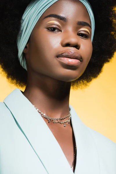 African american young woman in blue stylish outfit isolated on yellow — Stock Photo