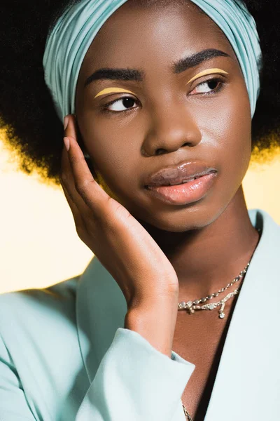 African american young woman in blue stylish outfit isolated on yellow — Stock Photo