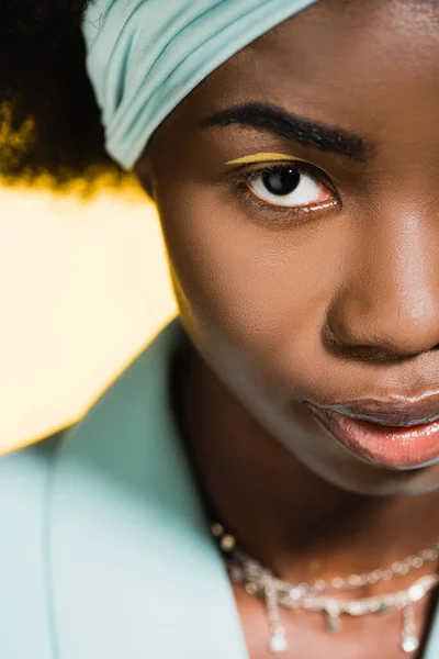 Closeup of african american young woman in blue stylish outfit isolated on yellow — Stock Photo
