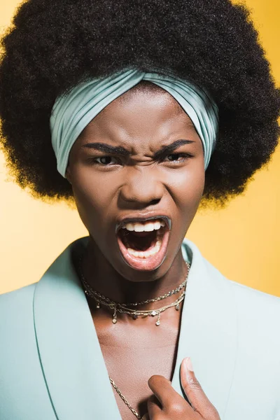 Irritado Africano americano jovem mulher em azul elegante roupa gritando isolado no amarelo — Fotografia de Stock