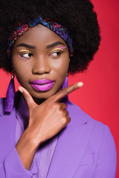 Afrikanisch-amerikanische junge Frau in lila stylischem Outfit zeigt vereinzelt auf rot — Stockfoto