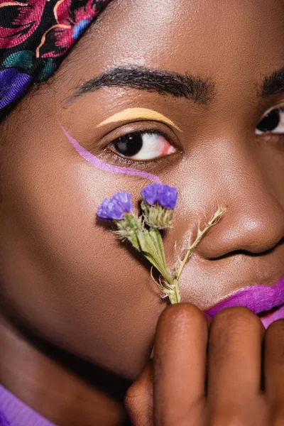 Primo piano della giovane donna afroamericana con fiore viola — Foto stock