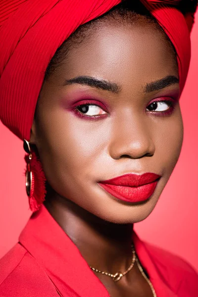 Afro-americana jovem mulher em roupa elegante e turbante isolado no vermelho — Fotografia de Stock