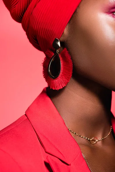 Closeup of african american young woman in earring isolated on red — Stock Photo