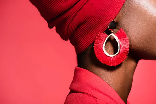 Vista recortada de de mujer joven afroamericana en elegante pendiente aislado en rojo - foto de stock