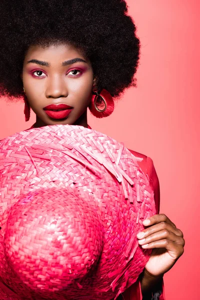 African american young woman with straw hat isolated on red — Stock Photo