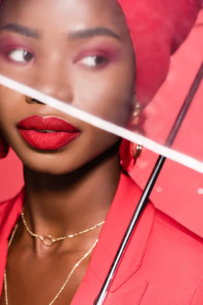 Afro-americana jovem mulher em roupa elegante e turbante isolado no vermelho — Fotografia de Stock