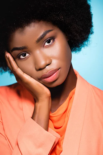 Africano americano giovane donna in arancione elegante vestito isolato su blu — Foto stock