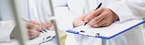 Ausgeschnittene Ansicht des Apothekers mit Stift beim Schreiben auf Klemmbrett, Banner — Stockfoto