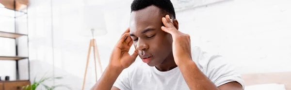 Afroamerikaner leidet unter Kopfschmerzen im Schlafzimmer, Banner — Stockfoto