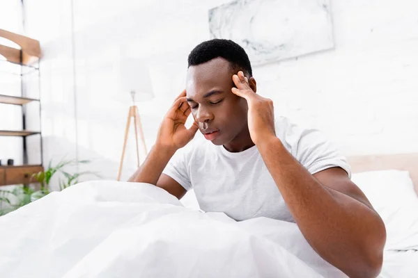 Afroamerikaner hat Kopfschmerzen auf dem Bett zu Hause — Stockfoto