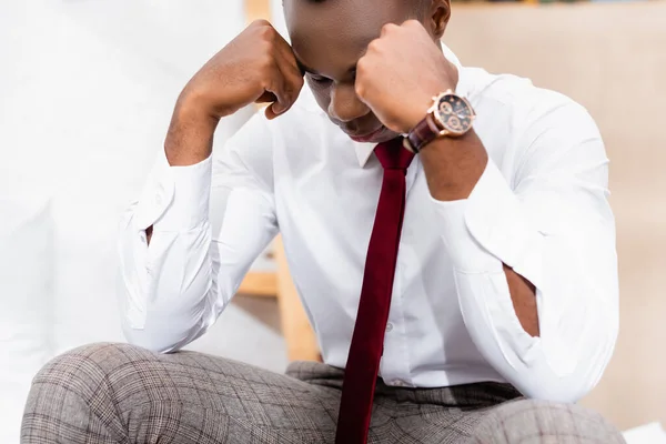 Disappointed african american businessman sitting at home — Stock Photo