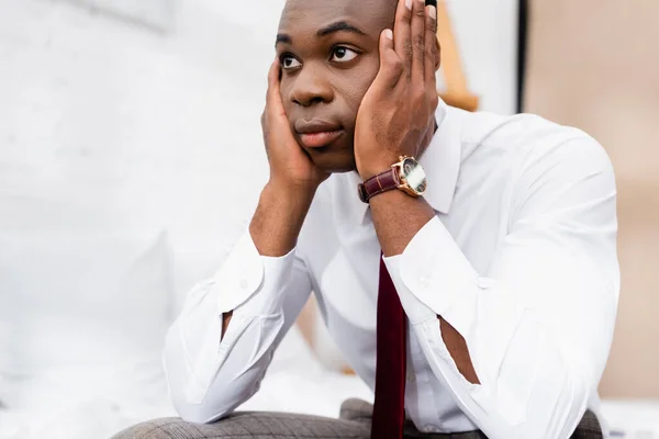 Uomo d'affari afroamericano con le mani vicino alla testa guardando lontano a casa — Foto stock