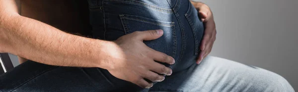 Ausgeschnittene Ansicht von Mann berührt Gesäß von Freundin in Jeans isoliert auf grau, Banner — Stockfoto