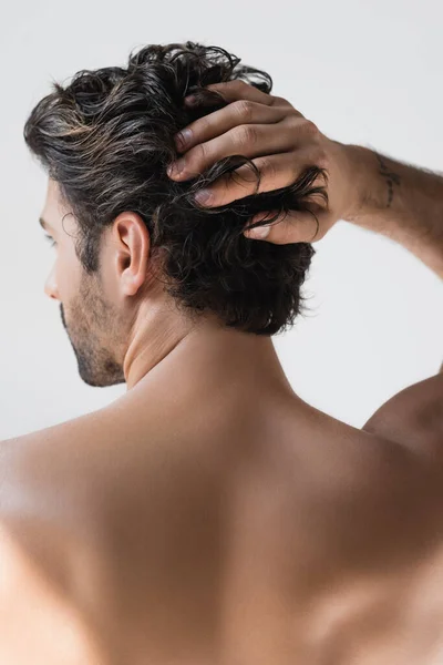 Vista trasera del hombre sin camisa con la mano cerca de la cabeza aislada en gris - foto de stock