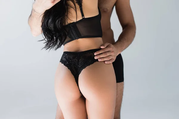 Cropped view of man embracing sensual woman in bra and panties isolated on grey — Stock Photo